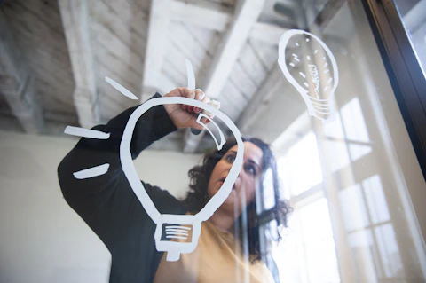 Drawing a lightbulb on glass with a chalk marker Getty Images 1141931576